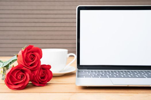 Red rose and coffee cup with laptop mockup on wood background, Valentine concept