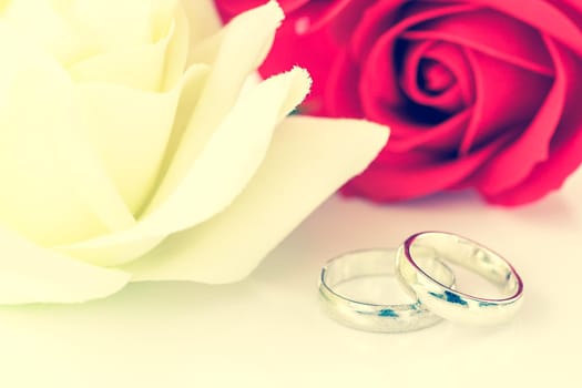 Close up red rose and wedding ring on white background, Wedding concept with roses and ring