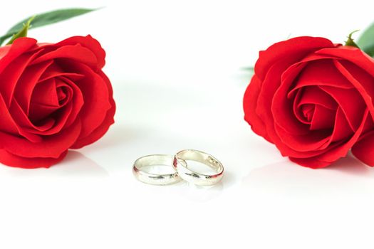 Close up red rose and wedding ring on white background, Wedding concept with roses and ring