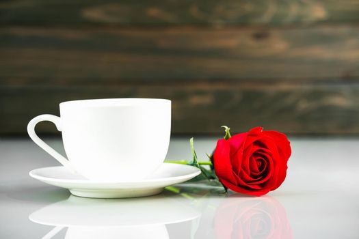 Red roses and coffee cup on table with copy space, Valentine's day concept with red roses