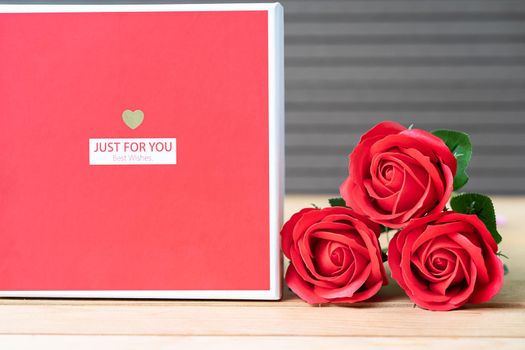 Close up red roses and heart-shaped box on wood background,Valentines Day concept with roses and red heart-shaped box