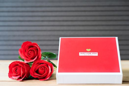 Close up red roses and heart-shaped box on wood background,Valentines Day concept with roses and red heart-shaped box