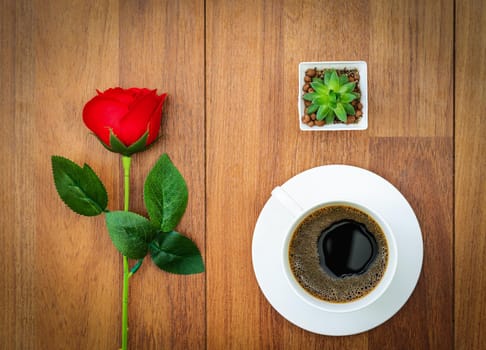 White cup of coffee and red rose on wood background valentine concept