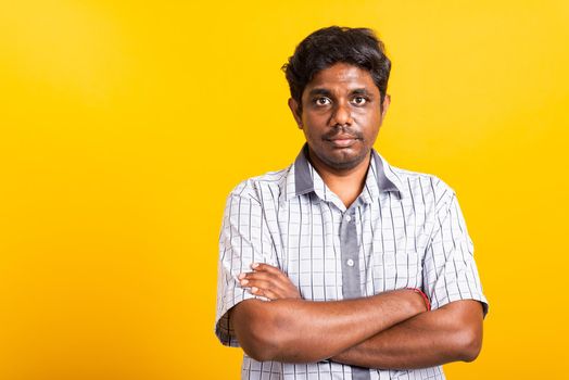 Closeup Asian happy portrait young black man standing cross arms chest confident pose and looking camera, studio shot isolated on yellow background