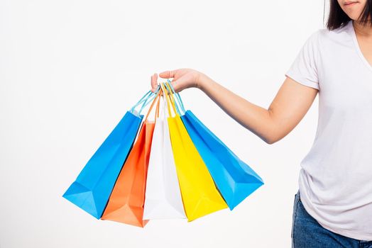 Happy woman hand holding shopping bags multicolor, young female hold many packets within arms isolated on white background, Black friday sale concept