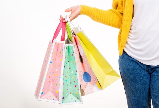 Happy woman hand she wears yellow shirt holding shopping bags multicolor, young female hold many packets within arms isolated on white background, Black Friday sale concept