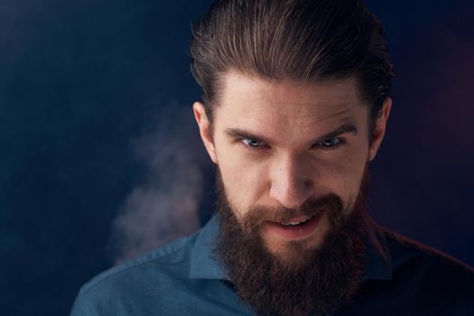 Emotional man black shirt attractive look close-up smoke in the background. High quality photo