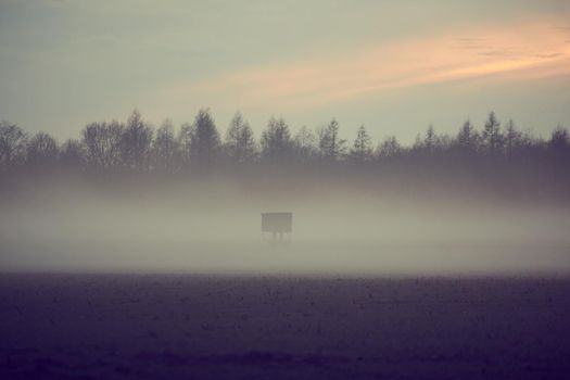 A landscape in the evening with fog and sunset