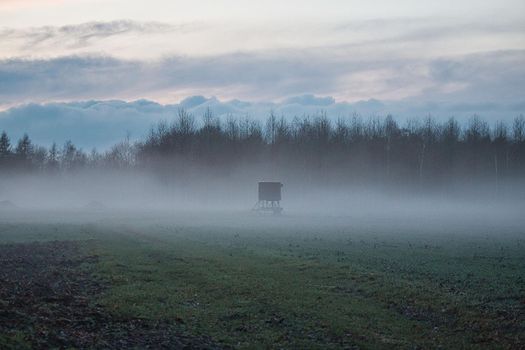 A landscape in the evening with fog and sunset