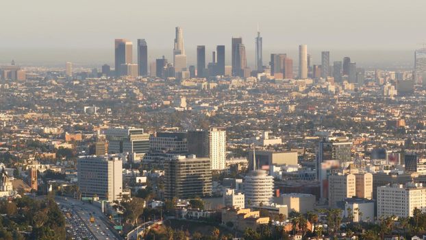 Highrise skyscrapers of metropolis and busy rush hour highway, Los Angeles, California USA. Urban downtown skyline and traffic jam. Aerial view of cityscape and cars on driveway. Freeway in LA city.