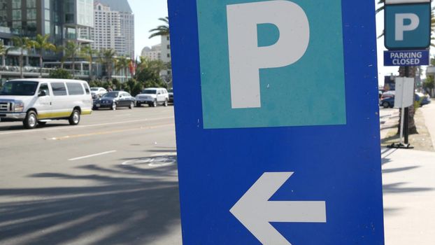 Parking lot sign as symbol of traffic difficulties and transportation issues in busy urban areas of USA. Public paid parking zone in downtown of San Diego, California. Limited space for cars in city.