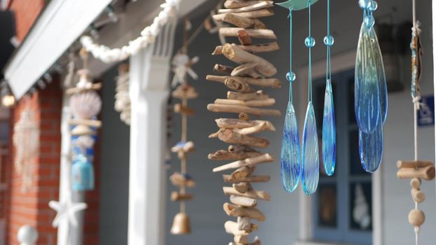 Nautical style hanging seashells decoration, beachfront blue wooden holiday home, pacific coast, California USA. Marine pastel interior decor of beach house in breeze. Summertime sea wind aesthetic.