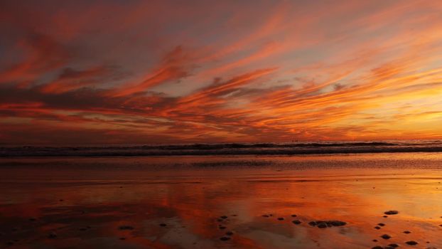 California summertime beach aesthetic, golden sunset. Vivid dramatic clouds over pacific ocean waves. Santa Monica popular resort, Los Angeles CA USA. Atmospheric moody purple evening sundown in LA.