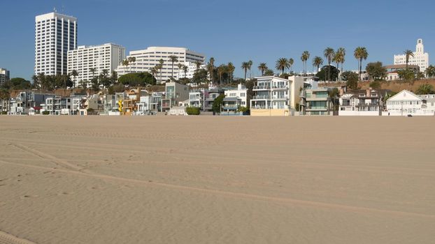 California summertime beach aesthetic, sunny blue sky, sand and many different beachfront weekend houses. Seafront buildings, real estate in Santa Monica pacific ocean resort near Los Angeles CA USA.