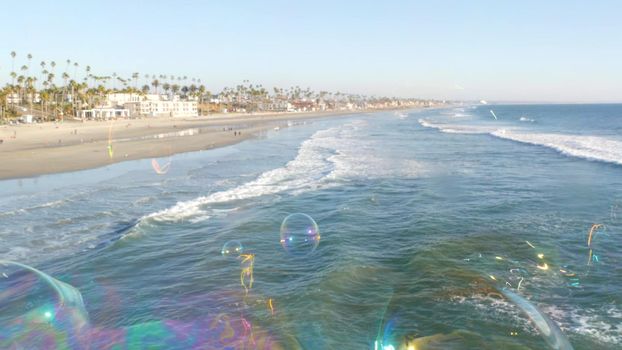 Soap bubbles on pier in California, blurred summertime seamless looped background. Creative romantic metaphor, concept of dreaming, happiness and magic. Abstract symbol of childhood, fantasy, freedom.