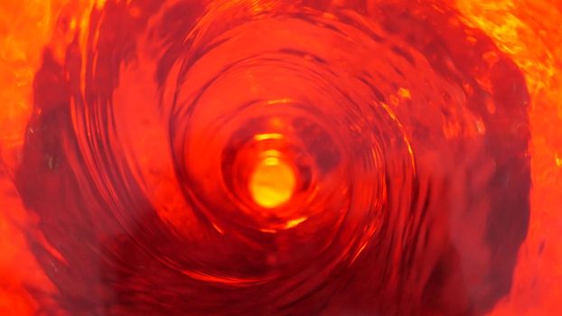 Symbol of hell, inferno and infinity. Red liquid hypnotic looped aqua swirl turning. Meditative luminous whirlpool. Mesmerising spiral tunnel of crystal fluid. Fiery surreal rhythmic water gradient.