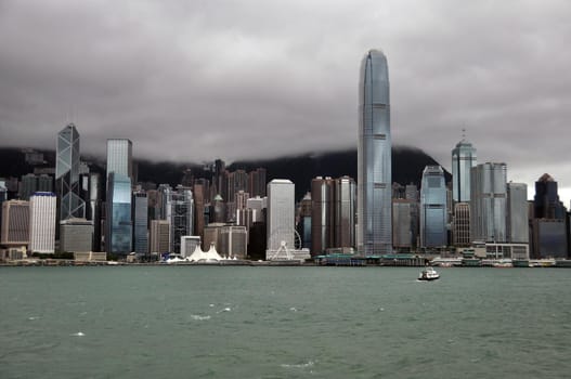 Hong Kong panorama in stormy day. Skyline of Hong Kong with rough waves of sea in stormy cloudy day