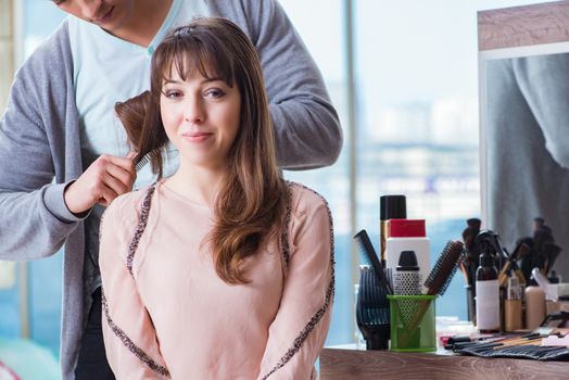 Man stylist working with woman in beauty salon