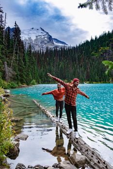 Majestic mountain lake in Canada. Upper Joffre Lake Trail View, couple visit Joffre Lakes Provincial Park - Middle Lake. British Columbia Canada, couple men and woman hiking by the lake