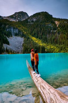 Majestic mountain lake in Canada. Upper Joffre Lake Trail View, couple visit Joffre Lakes Provincial Park - Middle Lake. British Columbia Canada, couple men and woman hiking by the lake