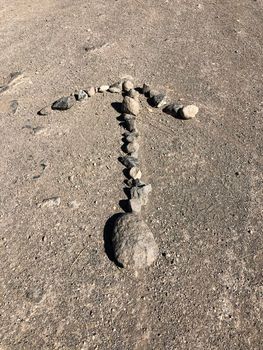 Arrow made by rocks on the road