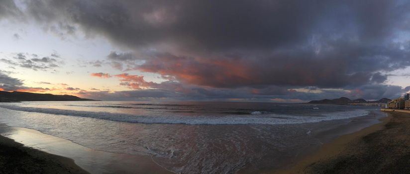Panorama from dark clouds above Las Canteras beach during sunset in Las Palmas, Gran Canaria