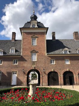 Statue and flowers at the Wasserburg Anholt castle in Munsterland, Germany