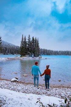 Minnewanka lake in Canadian Rockies in Banff Alberta Canada with turquoise water is surrounded by coniferous forests. Lake Two Jack in the Rocky Mountains of Canada. couple hiking by the lake Banff Canada