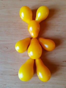 This funny figurine of a hare is made of ripe yellow tomatoes and lies on the kitchen table.