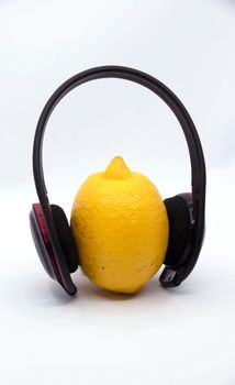 Yellow lemon in headphones on a white background.