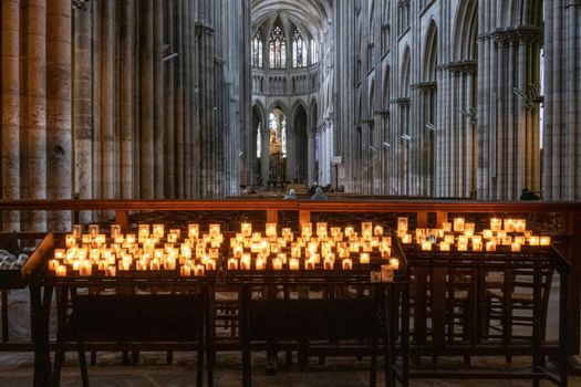 Rouen Cathedral Normandy France 9.25.2019 one of the greatest examples of the high gothic church from 13th cent. Votive candles in foreground and the high vaulted ceilings towards the altar in the background. High quality photo