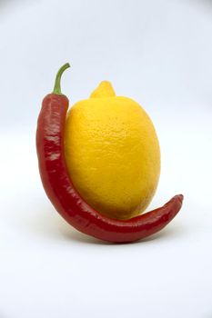 Yellow lemon with bitter red pepper on a white background.