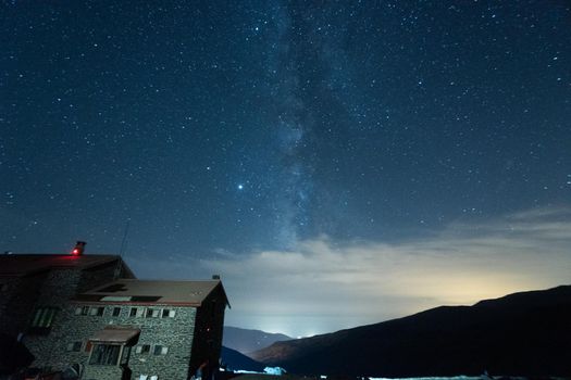 Starry sky surrounded by mountains and the via láctea