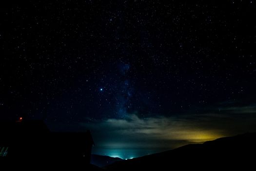 Starry sky surrounded by mountains and the via láctea