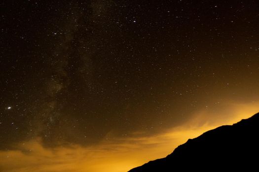 Starry sky surrounded by mountains and the via láctea