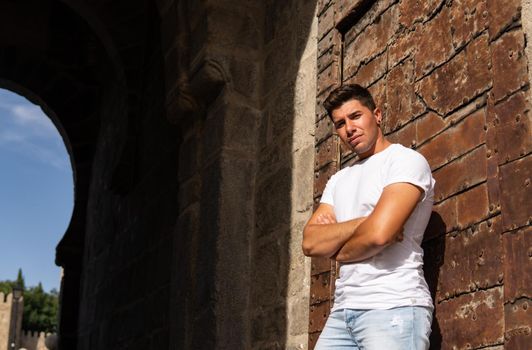 Man with an intense look on a rusty background, white T-shirt and black earring