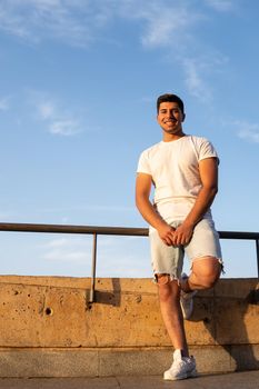 Boy with white T-shirt and brown hair with sky in the background