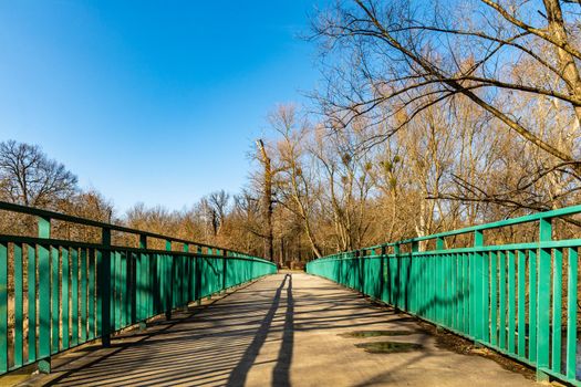 Long concrete bridge over river with green metal railing