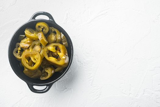 Slices of preserved Jalapeno peppers, on white background, top view flat lay with copy space for text