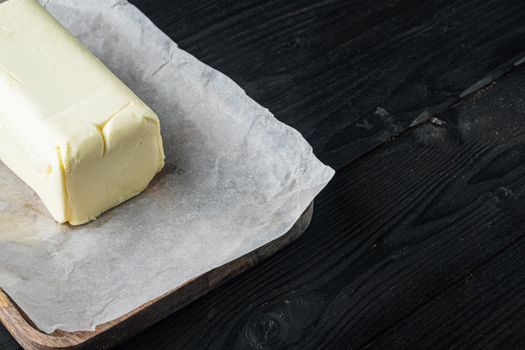 Fresh butter package, on black wooden table background with copy space for text