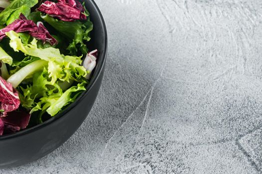 Bowls with mixed shredded salad lettuce fresh leaves, on gray background with copy space for text