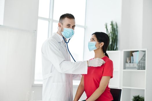 doctor examines woman in medical mask red t-shirt stethoscope . High quality photo