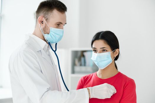 doctor with a stethoscope examines a patient wearing a medical mask breathing lungs health. High quality photo