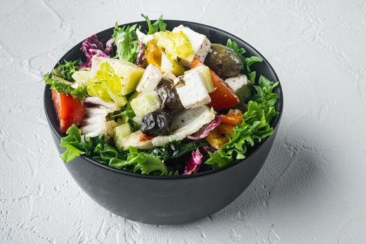 Tasty greek salad with feta, olives and tomatoe, on white background