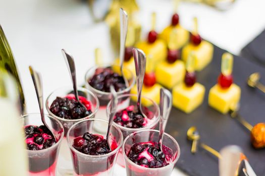 Delicious desserts on the Banquet table. Fruit, ice cream with jam, cheese appetizer on skewers