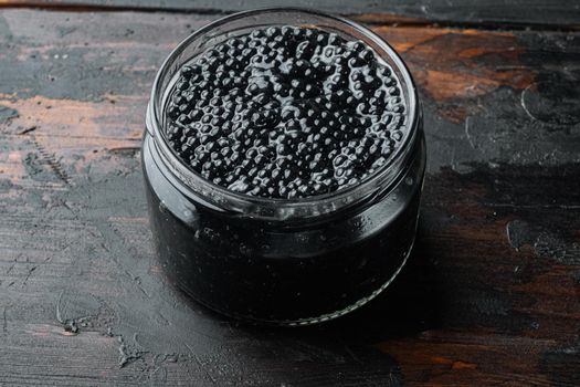 Black sturgeon caviar jar, on old dark wooden table background