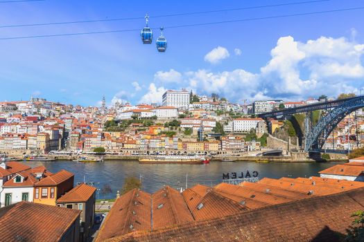 Porto, Portugal - October 23, 2020: View of the buildings with typical architecture and boats of tourist areas on the banks of the Douro river on an autumn day