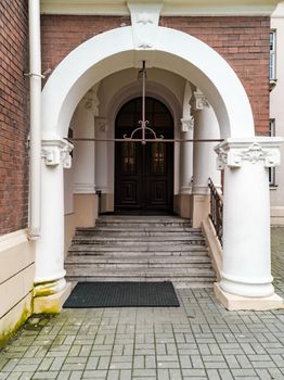 Concrete arch with stairs and doors as entrance to building