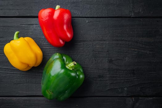 Sweet bell pepper, on black wooden table background, top view flat lay with copy space for text