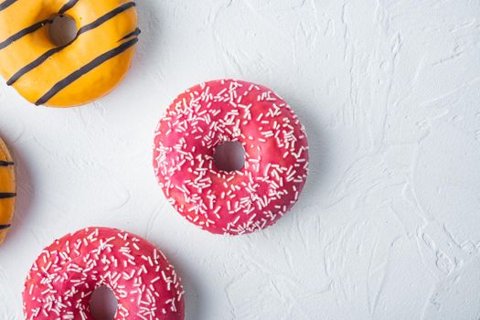 Various decorated, doughnuts, on white background, top view flat lay with copy space for text
